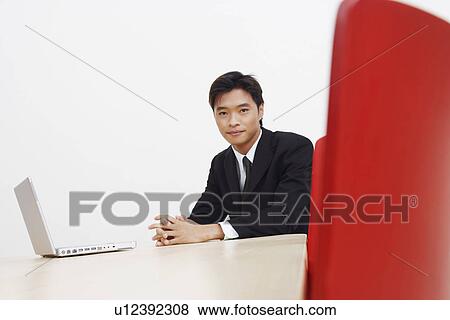 Stock Photo - Portrait of a businessman with a laptop in a board room. Fotosearch