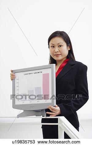Stock Image - Portrait of a businesswoman showing a growth chart. Fotosearch