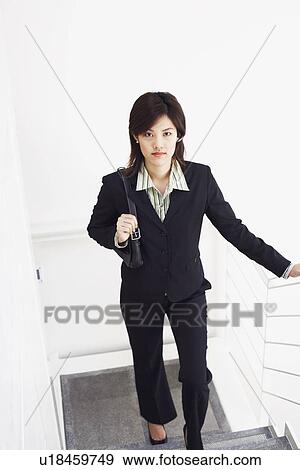 Portrait of a businesswoman walking up a staircase View Large Photo Image Stock Photo - Portrait of a businesswoman walking up a staircase. Fotosearch