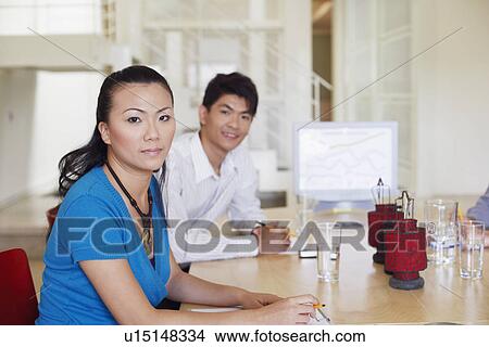 Portrait of a businesswoman with a businessman at a conference table View Large Photo Image Picture - Portrait of a businesswoman with a businessman at a conference table. Fotosearch