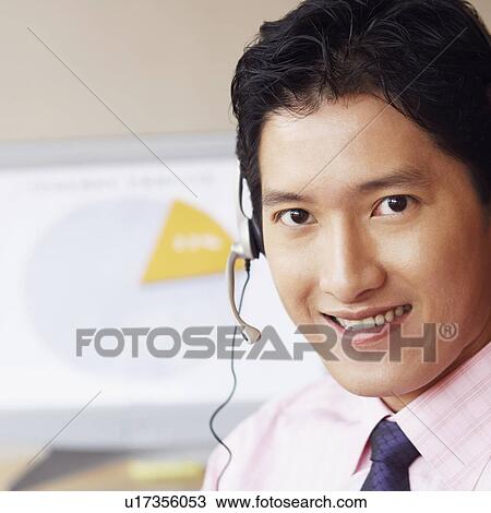 Stock Image - Portrait of a male customer service representative smiling. Fotosearch