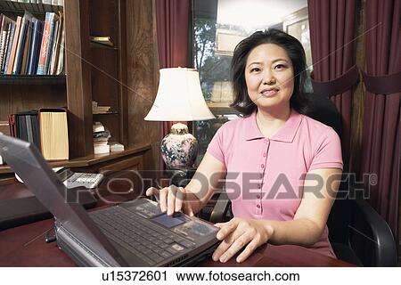 Stock Image - Portrait of a mature woman using a laptop. Fotosearch