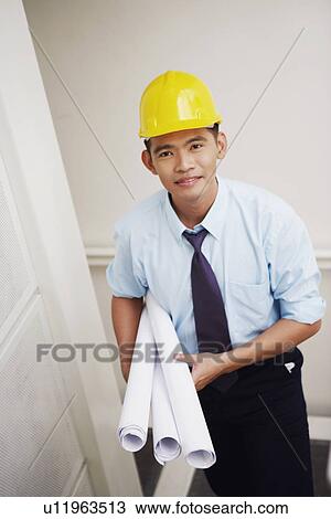 Portrait of an architect walking down stairs and carrying blueprints View Large Photo Image Stock Image - Portrait of an architect walking down stairs and carrying blueprints. Fotosearch
