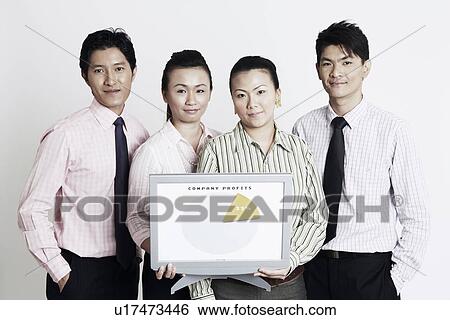 Stock Photograph - Portrait of two businesswomen with two businessmen holding a progress report and smiling. Fotosearch