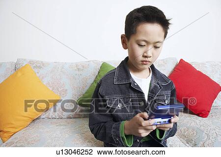 Close-up of a boy playing a video game View Large Photo Image Stock Image - Close-up of a boy playing a video game. Fotosearch