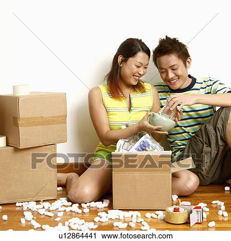 Close-up of a young couple sitting on the floor and looking at a teapot View Large Photo Image Stock Image - Close-up of a young couple sitting on the floor and looking at a teapot. Fotosearch