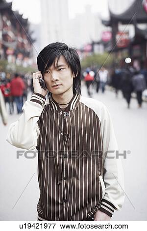 Stock Photo - Close-up of a young man using a mobile phone. Fotosearch