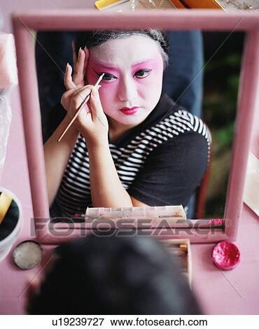 High angle view of a young woman applying eyeliner View Large Photo Image Stock Photo - High angle view of a young woman applying eyeliner. Fotosearch