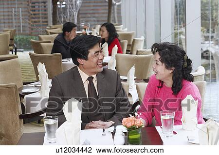 Mature couple sitting in a restaurant looking at each other View Large Photo Image Stock Image - Mature couple sitting in a restaurant looking at each other. Fotosearch