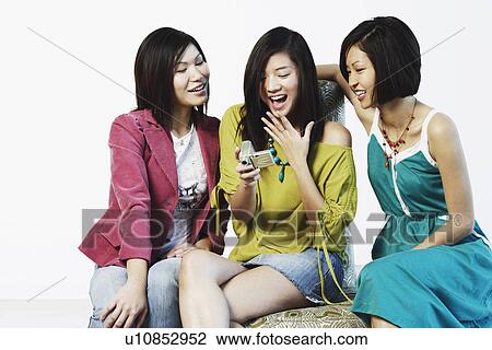 Three young women looking at a digital camera View Large Photo Image Stock Image - Three young women looking at a digital camera. Fotosearch