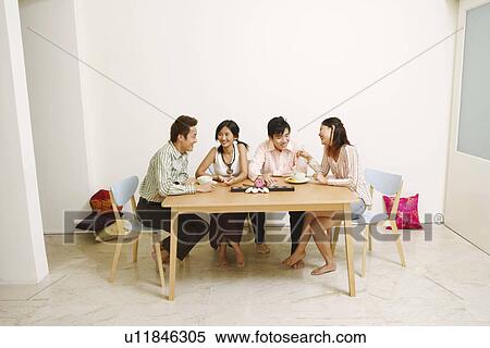 Stock Photography - Two young couples sitting and smiling. Fotosearch