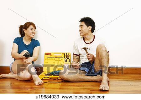 Young couple sitting together on the floor and smiling View Large Photo Image Stock Photo - Young couple sitting together on the floor and smiling. Fotosearch