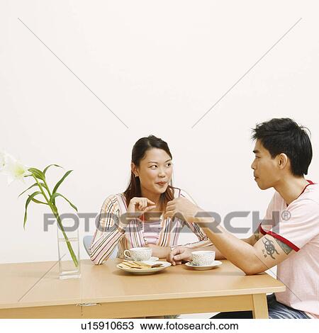 Young woman and a mid adult man looking at each other View Large Photo Image Stock Image - Young woman and a mid adult man looking at each other. Fotosearch