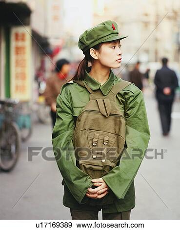 Stock Photo - Young woman in the army uniform standing in a street. Fotosearch