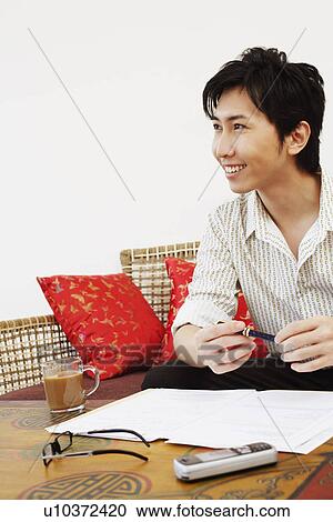 Young woman sitting on a couch and smiling View Large Photo Image Stock Image - Young woman sitting on a couch and smiling. Fotosearch