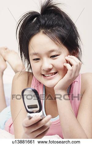 Stock Image - Close-up of a girl holding a mobile phone. Fotosearch