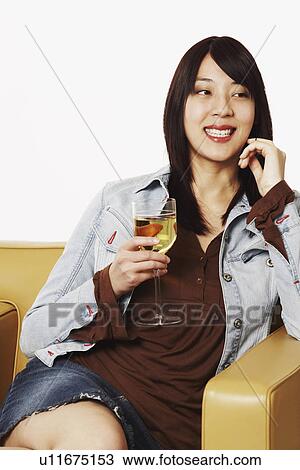 Stock Image - Close-up of a young woman holding a wineglass. Fotosearch