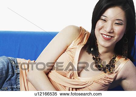 Close-up of a young woman lying on a couch View Large Photo Image Stock Photography - Close-up of a young woman lying on a couch. Fotosearch