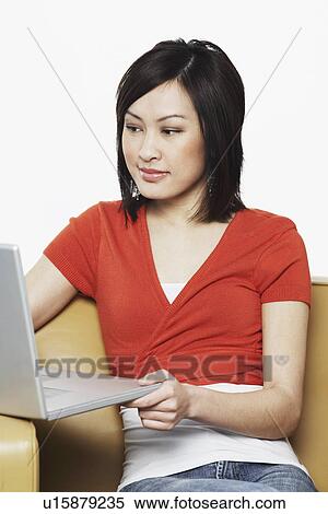 Close-up of a young woman using a laptop View Large Photo Image Stock Photography - Close-up of a young woman using a laptop. Fotosearch