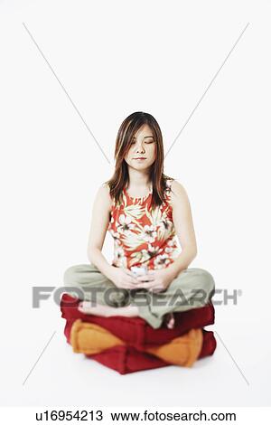 Mid adult woman sitting on cushions with her eyes closed View Large Photo Image Stock Image - Mid adult woman sitting on cushions with her eyes closed. Fotosearch