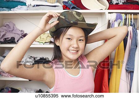 Portrait Of A Girl Holding A Hat On Her Head Stock