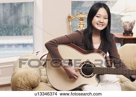 Picture - Portrait of a girl playing the guitar. Fotosearch