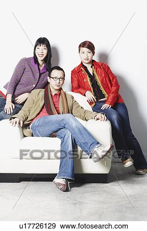 Portrait of a young man sitting with two young women View Large Photo Image Stock Photo - Portrait of a young man sitting with two young women. Fotosearch