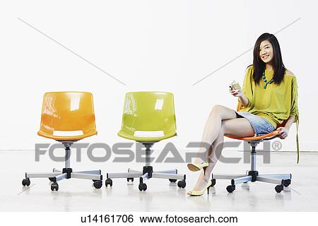 Stock Photograph - Portrait of a young woman holding a digital camera. Fotosearch