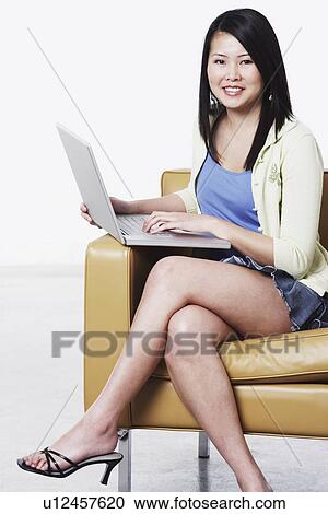 Stock Image - Portrait of a young woman using a laptop. Fotosearch