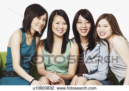 Portrait of four young women sitting on a couch smiling View Large Photo Image Stock Image - Portrait of four young women sitting on a couch smiling. Fotosearch