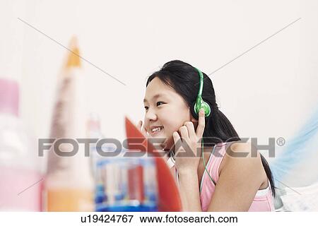 Side profile of a girl wearing headphones listening to music View Large Photo Image Stock Photo - Side profile of a girl wearing headphones listening to music. Fotosearch