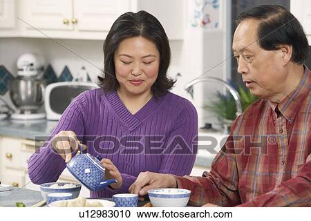 Close-up of a father looking at his daughter pouring tea View Large Photo Image Stock Image - Close-up of a father looking at his daughter pouring tea. Fotosearch