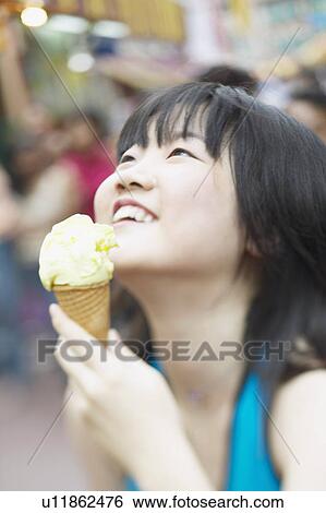 Close-up of a young woman holding an ice-cream cone View Large Photo Image Stock Photograph - Close-up of a young woman holding an ice-cream cone. Fotosearch