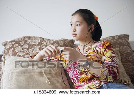 Stock Photo - Close-up of a young woman listening to music. Fotosearch
