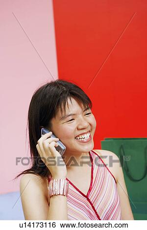 Stock Photograph - Close-up of a young woman talking on a mobile phone. Fotosearch