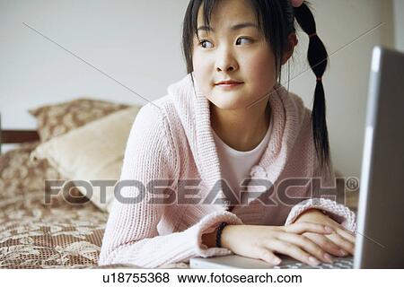 Stock Photo - Close-up of a young woman using a laptop. Fotosearch