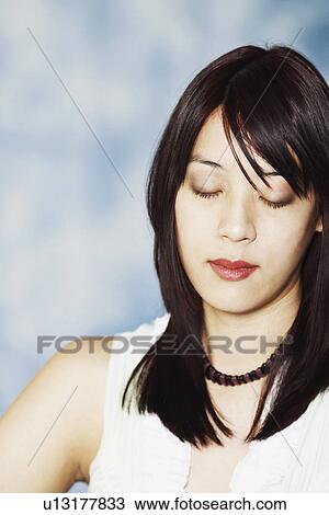 Stock Image - Close-up of a young woman with her eyes closed. Fotosearch