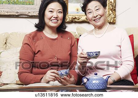 Portrait of a daughter and her mother holding tea cups View Large Photo Image Stock Photograph - Portrait of a daughter and her mother holding tea cups. Fotosearch
