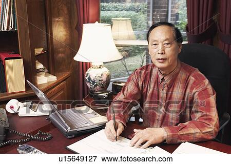 Stock Photo - Portrait of a senior man writing with a pen. Fotosearch