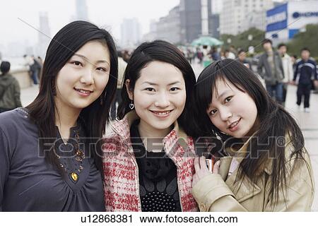 Stock Image - Portrait of three young women smiling. Fotosearch