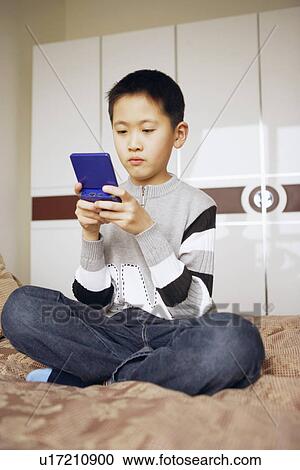 Stock Image - Boy playing a video game. Fotosearch