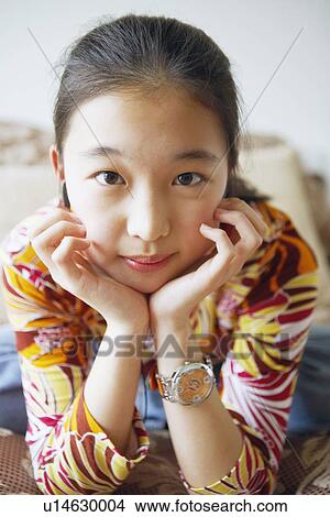 Close-up of a young woman with her hands on her chin View Large Photo Image Picture - Close-up of a young woman with her hands on her chin. Fotosearch
