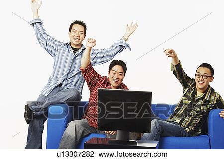 Close-up of three young men cheering in front of a flat screen monitor View Large Photo Image Stock Image - Close-up of three young men cheering in front of a flat screen monitor. Fotosearch