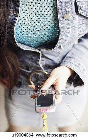 Picture - Mid section view of a woman using a mobile phone. Fotosearch