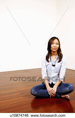 Portrait of a young woman sitting on the floor View Large Photo Image Stock Photograph - Portrait of a young woman sitting on the floor. Fotosearch