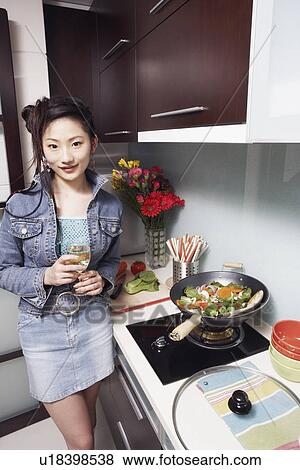 Portrait of a young woman standing holding a wineglass View Large Photo Image Stock Photo - Portrait of a young woman standing holding a wineglass. Fotosearch