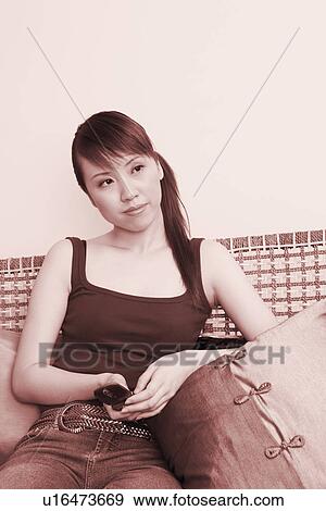 Stock Photo - Young woman holding a mobile phone. Fotosearch