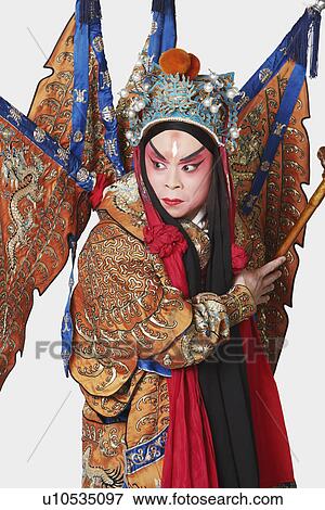 Stock Photo - Close-up of a male Chinese opera performer holding a weapon. Fotosearch