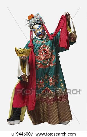 Stock Photo - Male Chinese opera performer holding a bowl full of gold coins. Fotosearch