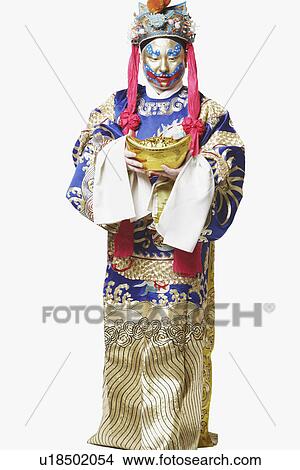 Picture - Male Chinese opera performer looking at a bowl full of gold coins. Fotosearch